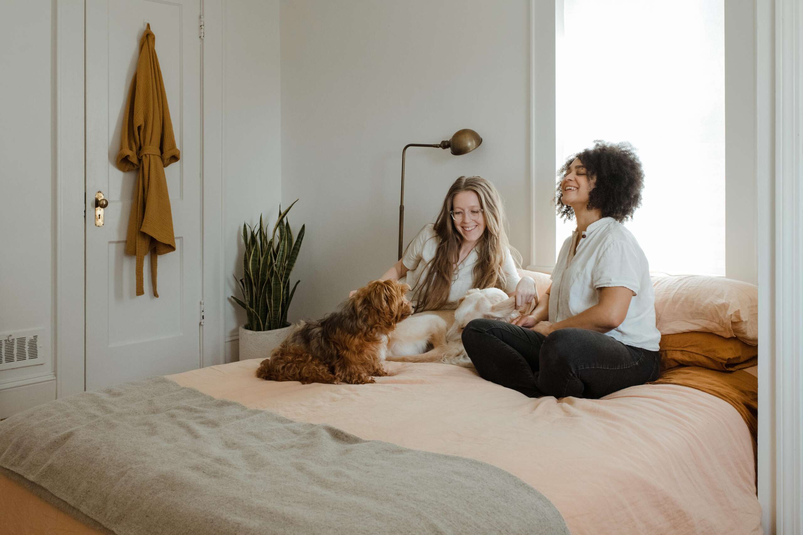 women on a bed with a dog enjoying their pest free home Avon Lake pest control near me exterminator